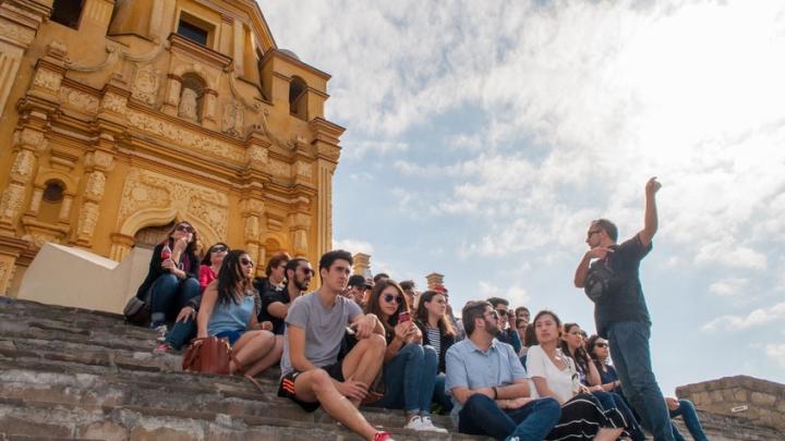 教授 speaks to a group of 赌博娱乐平台网址大全 students gathered on the steps of the Cerro del Obispado, a famous landmark in Monterrey, 墨西哥